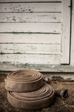 Fototapeta Boho - Two fire hoses in front of a peeling wooden wall