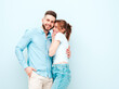 © halayalex - Smiling beautiful woman and her handsome boyfriend. Happy cheerful family having tender moments near light blue wall in studio.Pure cheerful models hugging.Embracing each other
