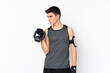 © luismolinero - Teenager sport man over isolated white wall making weightlifting with kettlebell