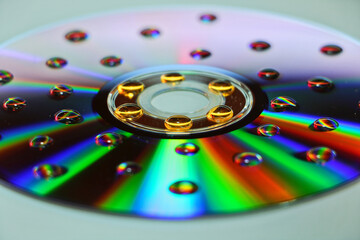 Wall Mural - Closeup shot of small water droplets on a CD on a white surface