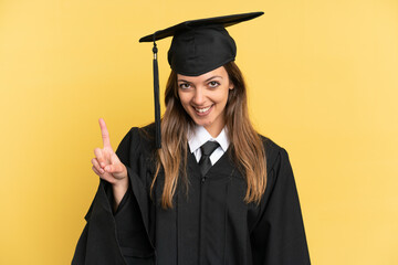 Young university graduate isolated on yellow background showing and lifting a finger in sign of the best