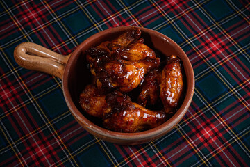 Sticker - Spicy grilled glazed chicken wings and drumsticks served on a rustic wooden pan.