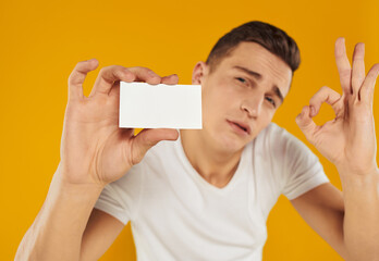 guy with a white card on a yellow background Copy Space mockup