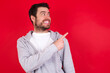 © Jihan - young handsome caucasian man in sports clothes against red background glad cheery demonstrating copy space look novelty