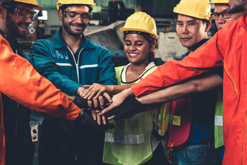 Skillful worker stand together showing teamwork in the factory . Industrial people and manufacturing labor concept .