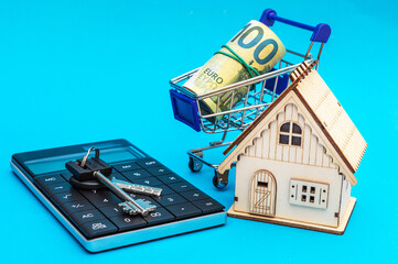 Wall Mural - Model of house, calculator, keys and shopping cart with euro bills on blue background. Buying real estate. Calculating tax for real estate.