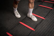 Closeup of footwork on an agility ladder. One foot inside the square. Fitness, cardio and intense sports training concept.