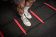 Closeup of footwork on an agility ladder. Feet inside the square. Fitness, cardio and intense sports training concept.