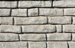 a fragment of a concrete figured wall of gray color in the form of a brickwork
