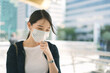 © dodotone - Adult business asian working woman wear face mask  sick with corona virus pandemic.
