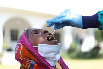 Canvas Print - Old Indian woman opening her mouth to take a covid-19 test and doctor's hand holding a swab