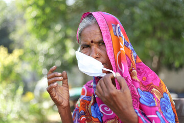 Sticker - Closeup shot of an Indian woman with a traditional dress wearing a mask