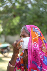 Poster - Vertical shot of an Indian woman wearing a white mask