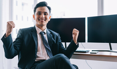 Asian businesswoman is smiling confidently beside two blank computer screens
