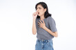 Sick young Asian woman in grey t-shirt and jeans feeling unwell and coughing as symptom for cold or bronchitis. Woman have symptoms of COVID-19. Healthcare concept..