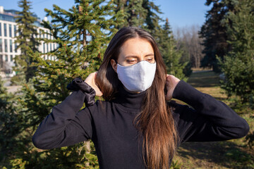 Poster - Shallow focus shot of a Caucasian woman wearing a white mask and posing in the park