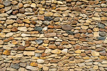 Wall Of Yellow Stone. Abstract Natural Background. Uneven Stone Surface.