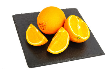 Wall Mural - Sliced sweet, juicy orange orange on black stone.