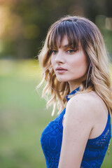 Canvas Print - Shallow focus shot of a confident Caucasian female in a blue dress posing for the camera