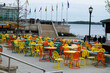 © Ashok Bhattarai/Wirestock - View of a cozy outdoor waterside cafe with colorful tables and chairs