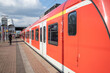 Regional train arrive and stop at outdoor platform railway station in Düsseldorf, Germany.