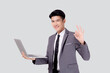 Young asian business man standing work on laptop computer to internet online isolated on white background, businessman confident and notebook, freelance with success, marketing and communication.