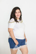 © Bangkok Click Studio - Portrait half body shot of Asian young happy cute friendly overweight fat teen long black hair female wears white shirt and short blue jeans stand smiling look at camera against white background.