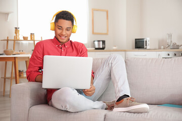 Wall Mural - African-American student studying online at home