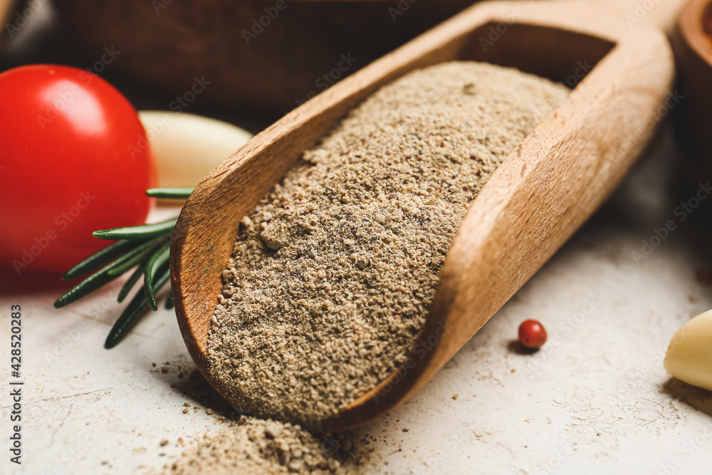 Scoop with powdered pepper on table, closeup