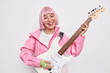 © wayhome.studio  - Talented stylish female musician plays electric guitar sings song enjoys rock music wears fashionable clothes feels happy isolated over white background. Popular singer on stage. Hobby concept
