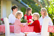 © famveldman - Family eating outdoor. Garden summer fun.