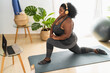 © Alessandro Biascioli - Young  African curvy woman doing pilates fitness class with laptop at home - Sport wellness people lifestyle concept