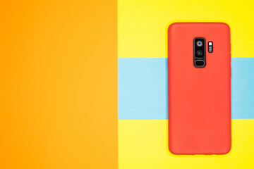 Poster - Closeup shot of a red mobile phone on a colorful surface