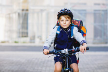 Schoolkid Boy In Safety Helmet Riding With Bike In The City With Backpack. Happy Child In Colorful Clothes Biking On Bicycle On Way To School. Safe Way For Kids Outdoors To School