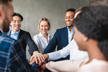 Wall Mural - Happy Colleagues Celebrating Business Success Holding Hands In Modern Office