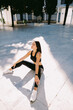© shevtsovy - Fitness woman doing stretching legs exercise outdoors. Sexy Female runner in sportswear exercising morning routine. Slim athletic woman run workout.