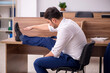 © Elnur - Young businessman employee doing sport exercises at workplace