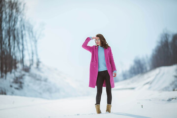 Wall Mural - Shallow focus shot of a beautiful Caucasian woman with glasses posing in the snowy forest