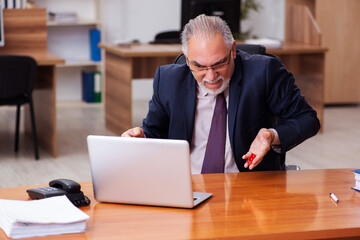 Sticker - Old male employee in gambling concept at workplace