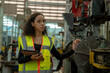 © visoot - Engineer woman working and checking with machine in the factory.