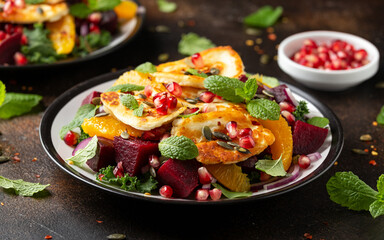 Wall Mural - Fried Halloumi Cheese salad with beetroot, orange, pomegranate and pumpkin seeds, red onion, green vegetables. healthy food