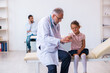 © Elnur - Small girl with her father visiting old male doctor