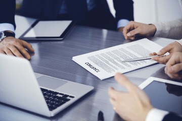 Business people discussing contract working together at meeting in modern office. Unknown businessman and woman with colleagues or lawyers at negotiation