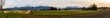 Panorama  mit Wiesen,  Bäumen und Bergen bei Hirschau am Chiemsee in Oberbayern 