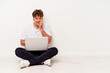 © Asier - Young caucasian man sitting on the floor holding on laptop isolated on white background biting fingernails, nervous and very anxious.