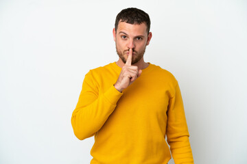 Young Brazilian man isolated on white background showing a sign of silence gesture putting finger in mouth