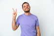 © luismolinero - Young Brazilian man isolated on white background smiling and showing victory sign
