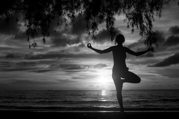 Wall Mural - Silhouette of yoga woman on the sea coast at sunset. Black and whaite photo.