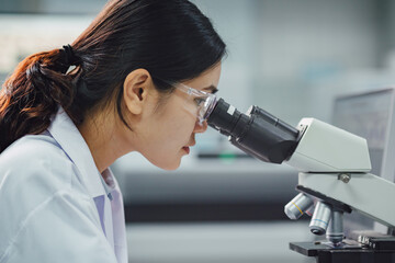 Medical doctor or scientist working in the laboratory. Using a microscope for research detect the virus or bacteria from samples. Medical and microbiologist science concept photo.