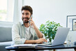 © baranq - Happy man talking on the phone working from home office